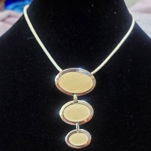 Cream cord necklace with a 3 cream and silver circle pendant